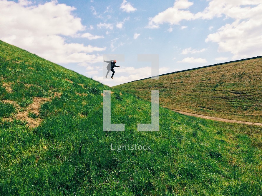 man jumping on a hill 