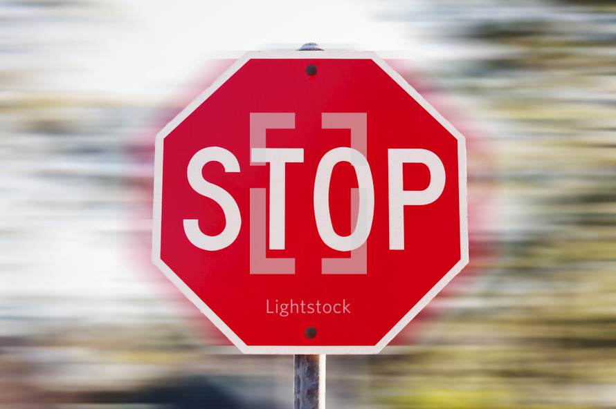 Stop sign against a fast-spinning background.