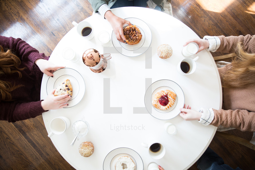 high angle of young women eating breakfast together at a table.