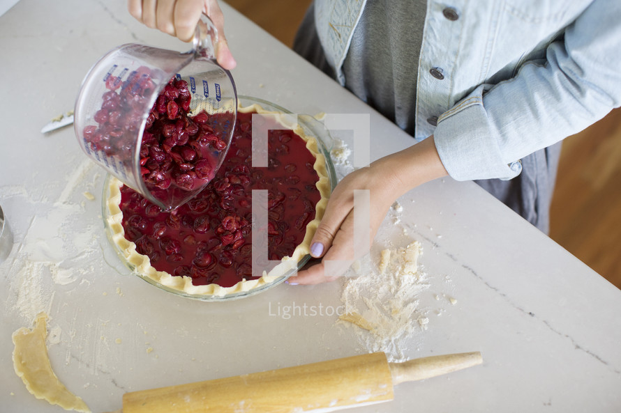 Woman making a home made cherry pie.