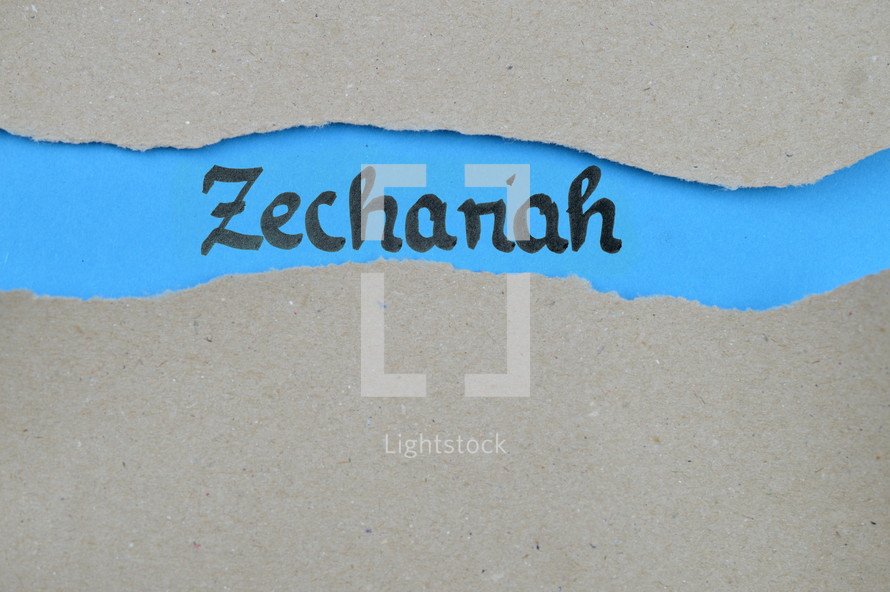 Zechariah - torn open kraft paper over blue paper with the name of the prophetic book Zechariah