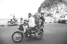 men carrying produce on a motorcycle in India 