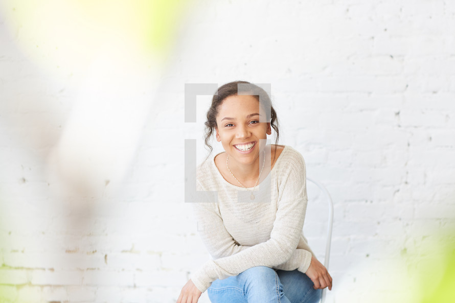 portrait of a woman sitting in a chair smiling 