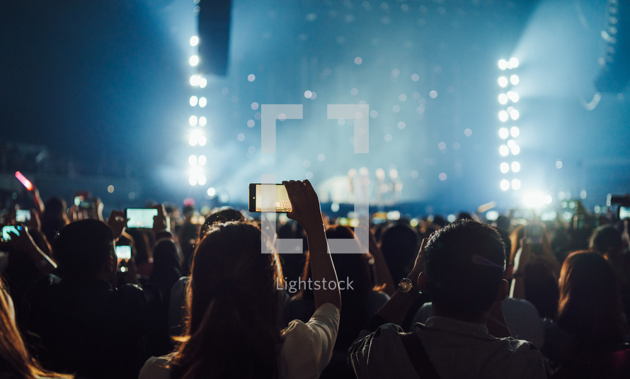 people filming a concert with their cellphones 