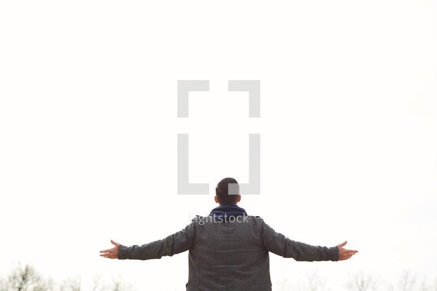 a man with outstretched arms looking up to God 