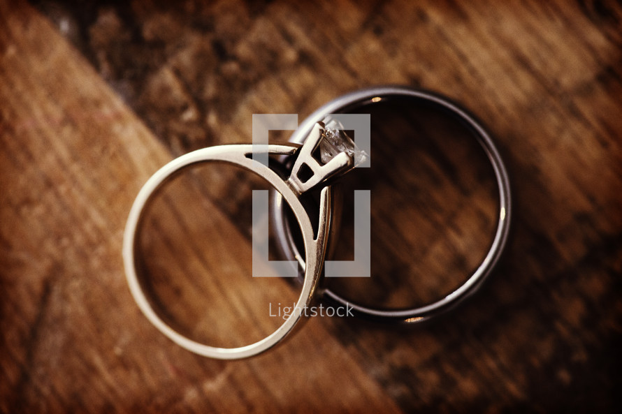 close up of two rings laying together on a table.