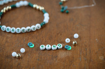 Jar of green, white, and gold beads with word - grateful and kind