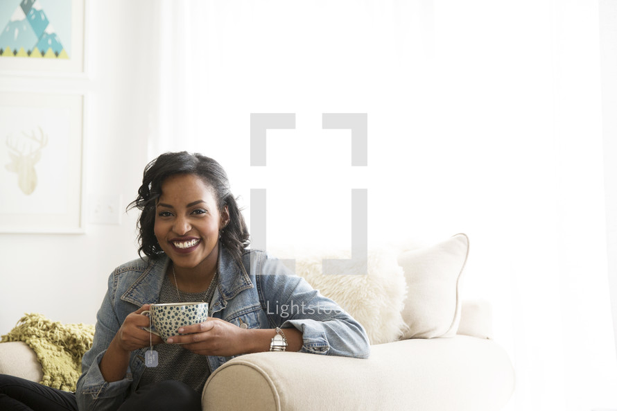An African American woman holding a cup of hot tea 