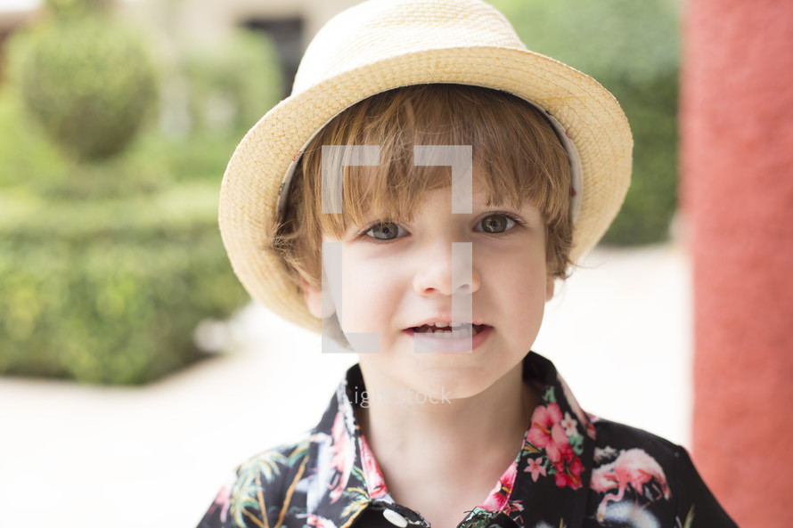 child in a straw hat and Hawaiian shirt 