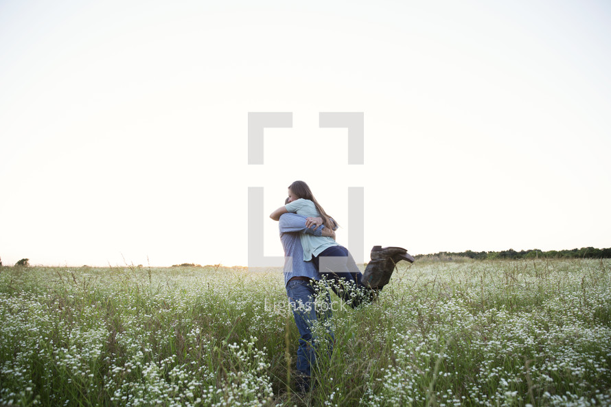 a couple embracing in a field 