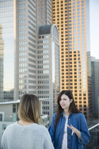 women talking on a city balcony 