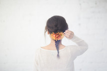 a woman with braided hair and flowers in her hair 