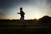 man running outdoors at sunset 