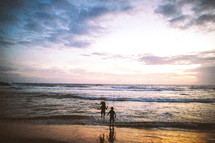 children at the beach at sunset 