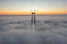 Aerial view of bridge through clouds at sunset