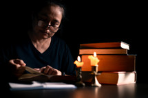 Bible and candlelight with studying woman