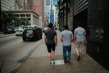 men walking down a city sidewalk 