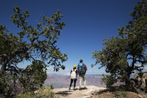 couple standing on a mountaintop with backpacks