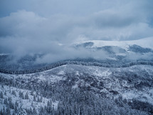 clouds over winter mountain forest 