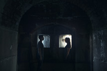 man and woman standing in a dark cellar 