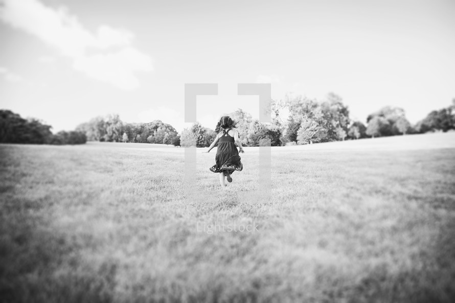 toddler girl running in the grass 