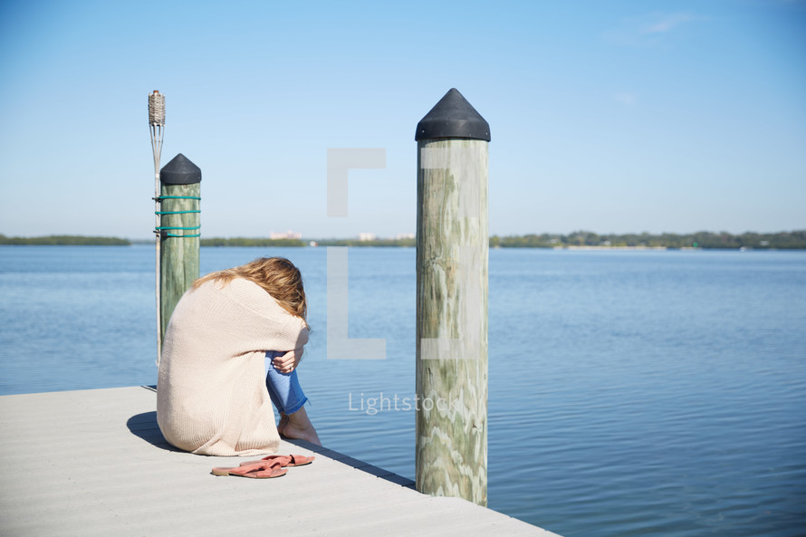 a woman crying on a pier 