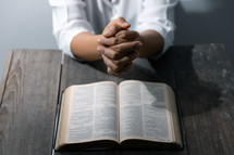 Woman praying with Bible and white background