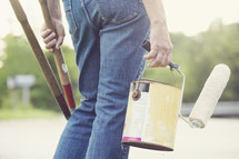 man carrying tools and paint supplies 