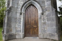 wooden arched door on a stone church 