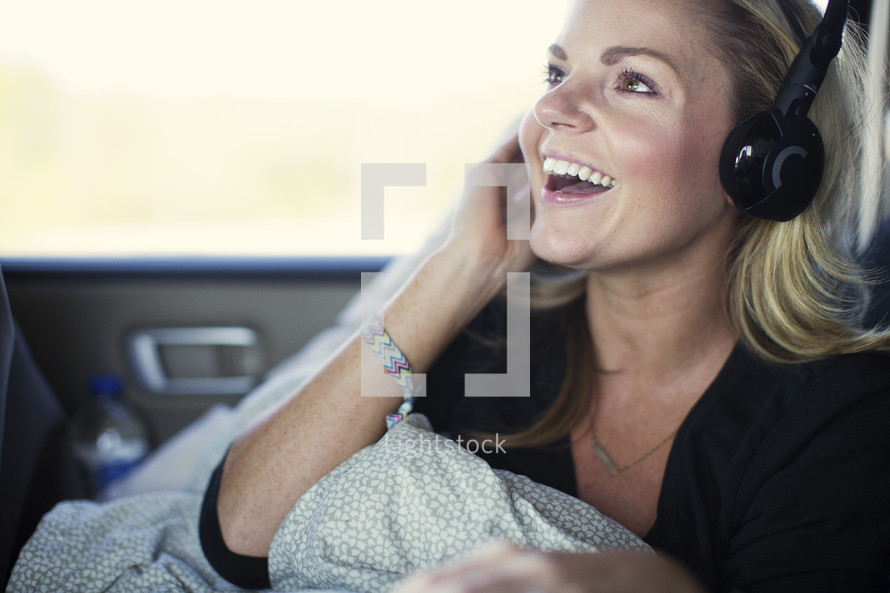 woman riding in a car listening to headphones 