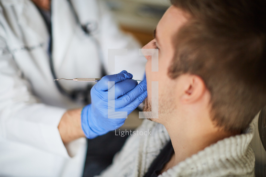 a dentist scrapping and cleaning teeth 