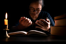 Bible and candlelight with studying woman