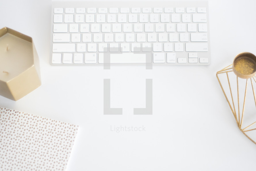 computer keyboard, candle, journal, on a desk 