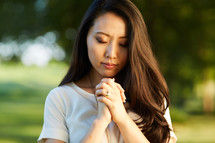 a woman praying outdoors 