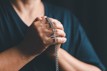 Silver cross necklace in hands
