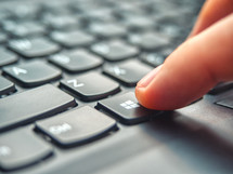 Laptop user pressing Windows Key on Microsoft Windows keyboard