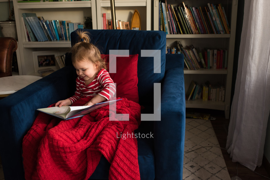 a little girl reading a children's book 