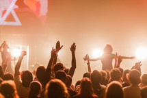 audience with raised hands in praise at a concert 