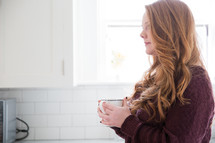 woman in thought holding a mug of coffee 