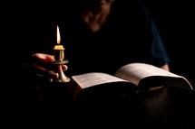 Bible and candlelight with studying woman