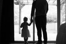 father and daughter looking out a window 