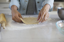 A woman's hands making a pie crust.