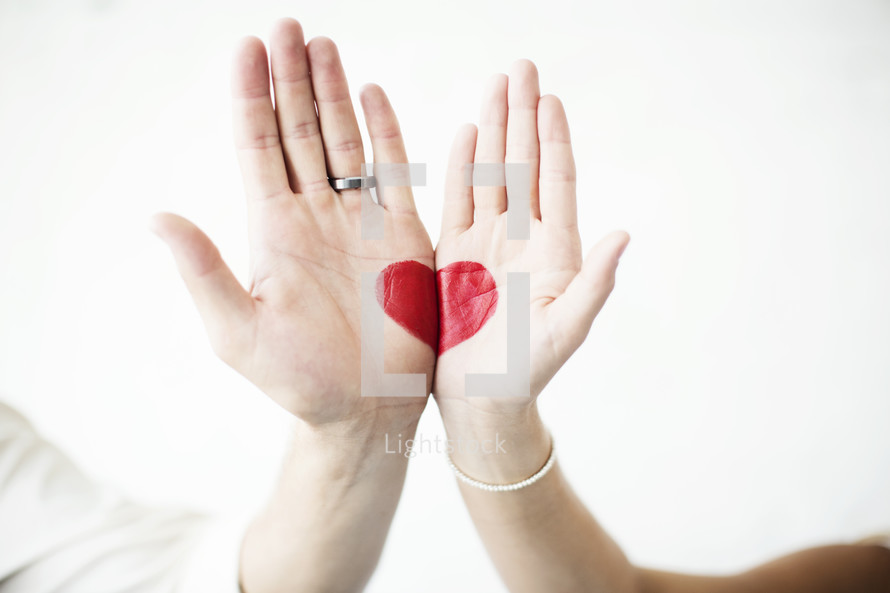 heart painted on the hands of a bride and groom 
