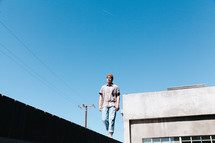 man walking on the edge of a roof 