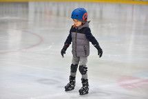 child ice skating in a helmet 