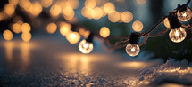Christmas time. String of glowing christmas lights on snow. Digital art image.