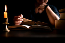 Bible and candlelight with studying woman