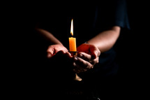 Bible and candlelight with praying hands