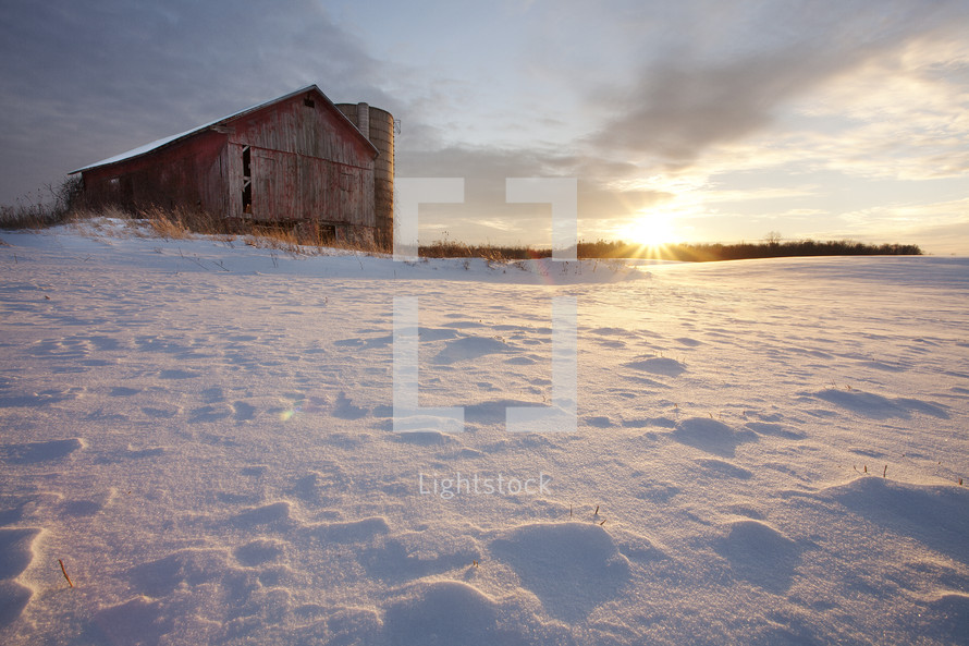 barn in snow at sunset 