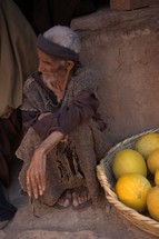 a poor man in biblical times sitting at a market 